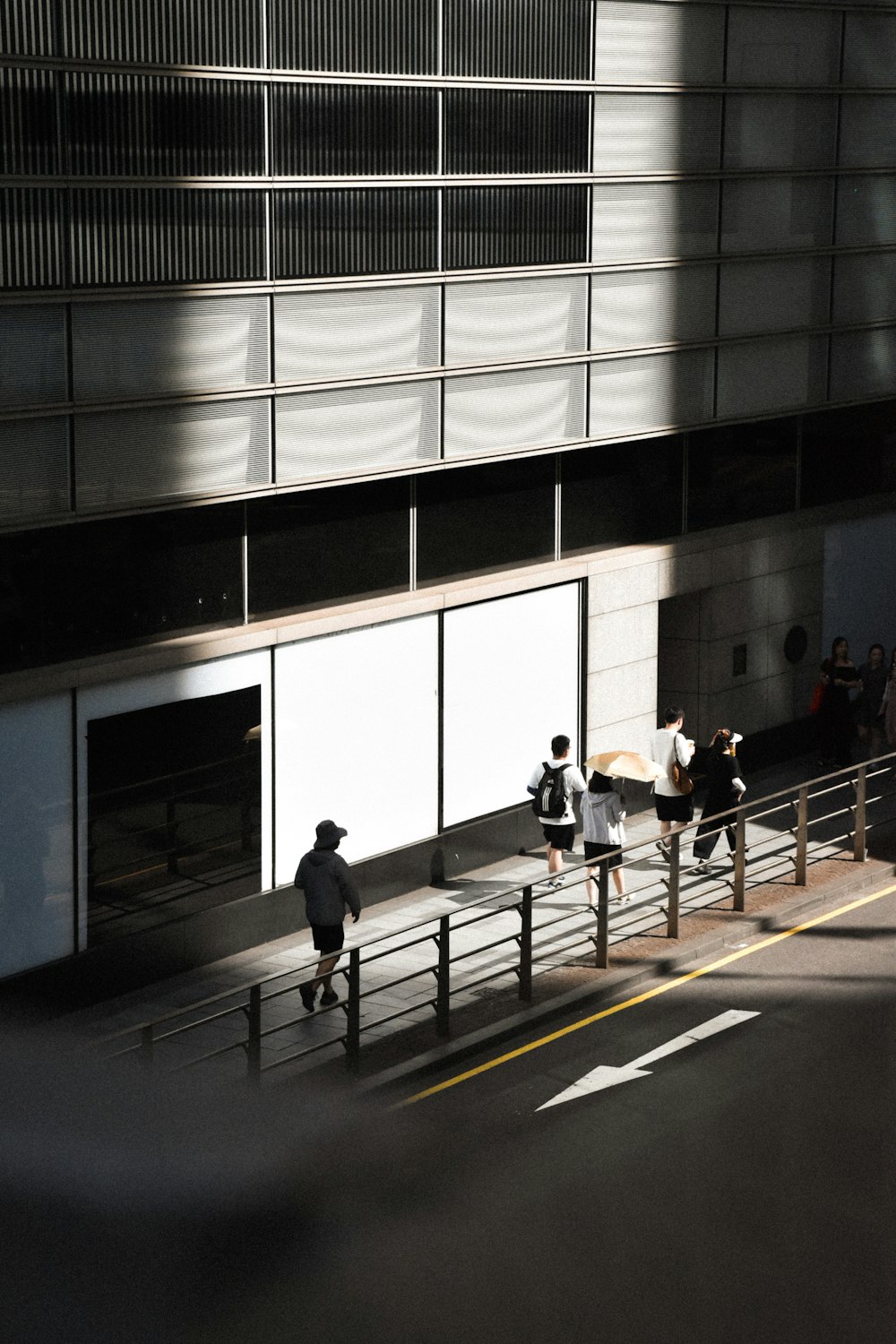 a group of people walking down a street next to a tall building