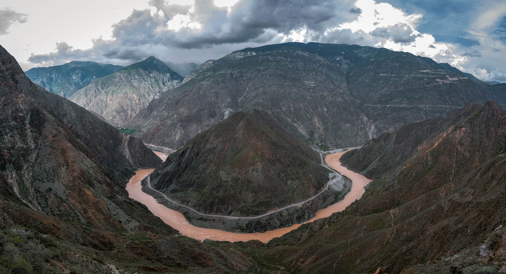 a river flowing through a valley surrounded by mountains