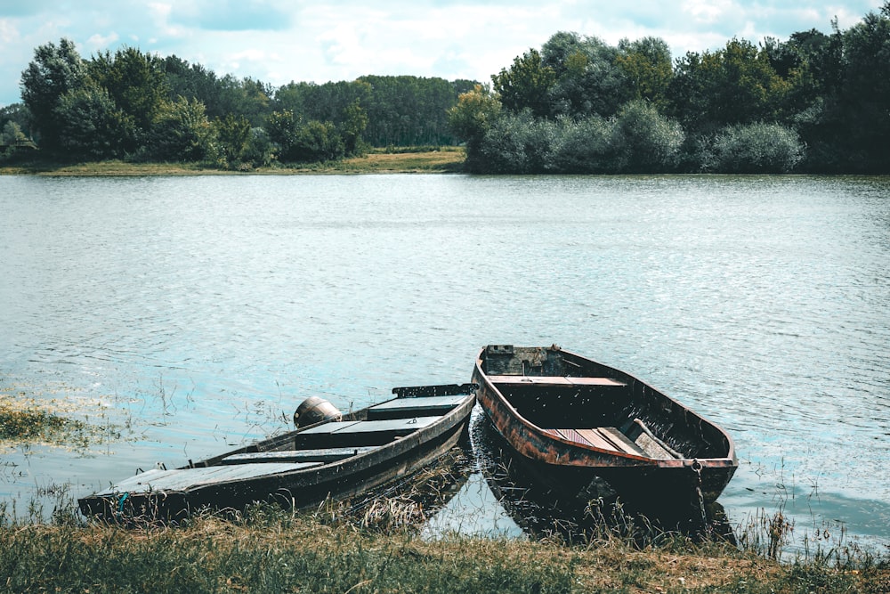 a couple of boats sitting on top of a lake