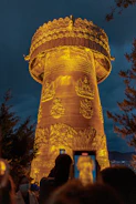 Children gathered around a guide pointing to the night sky near a traditional Bhutanese temple