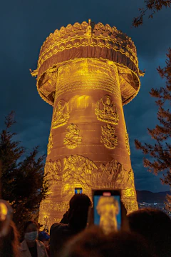 Children gathered around a guide pointing to the night sky near a traditional Bhutanese temple