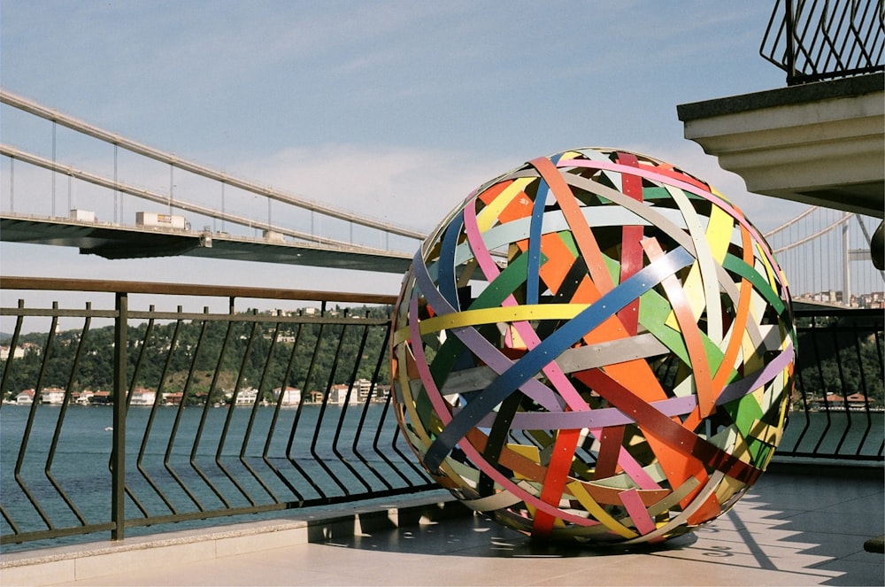 una grande palla colorata seduta in cima a un marciapiede