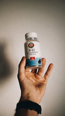 a person holding a bottle of vitamins in their hand