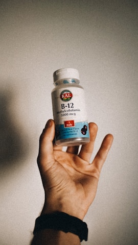 a person holding a bottle of vitamins b12 in their hand