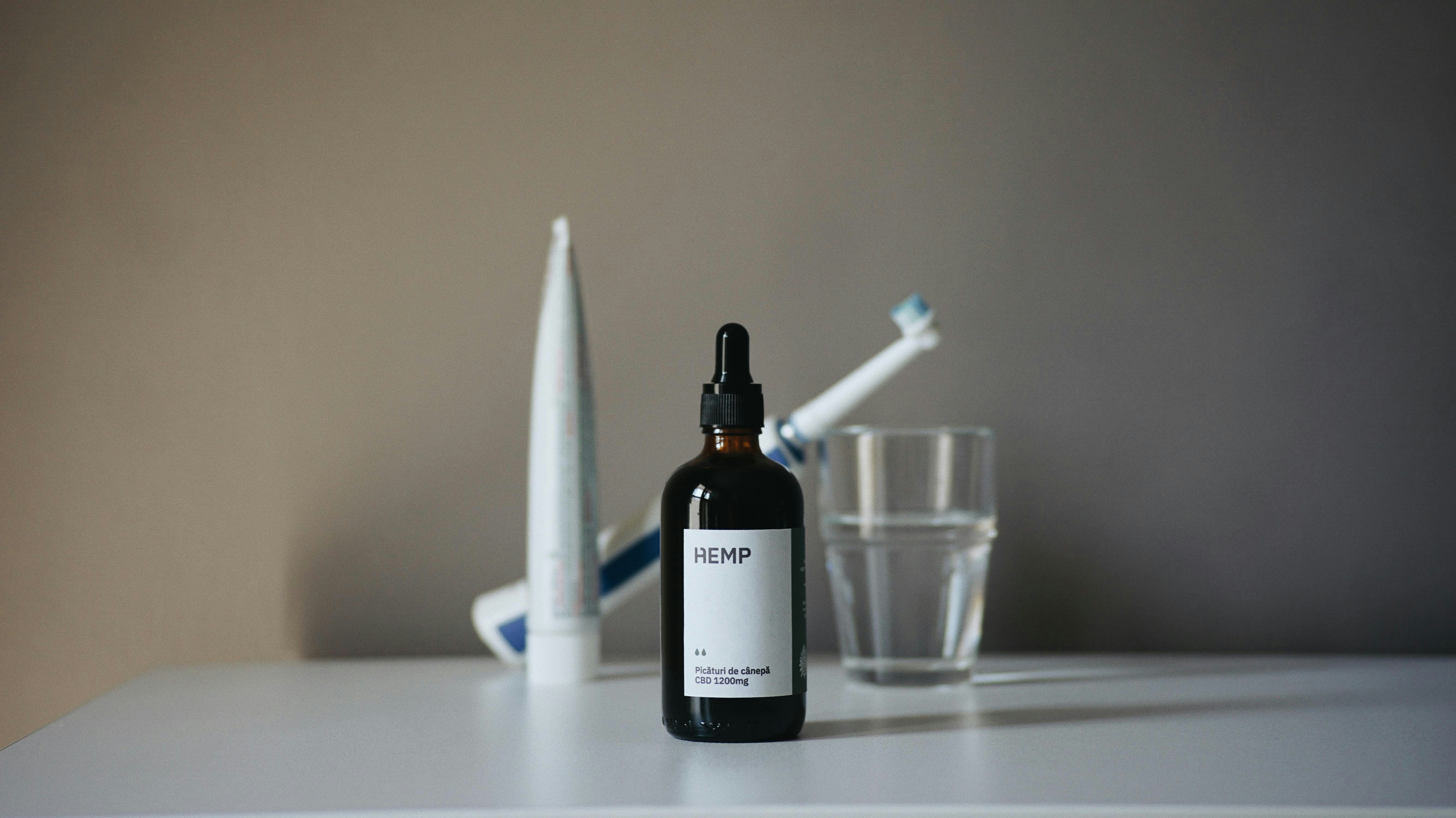 a bottle of liquid sitting on top of a table next to a toothbrush, 