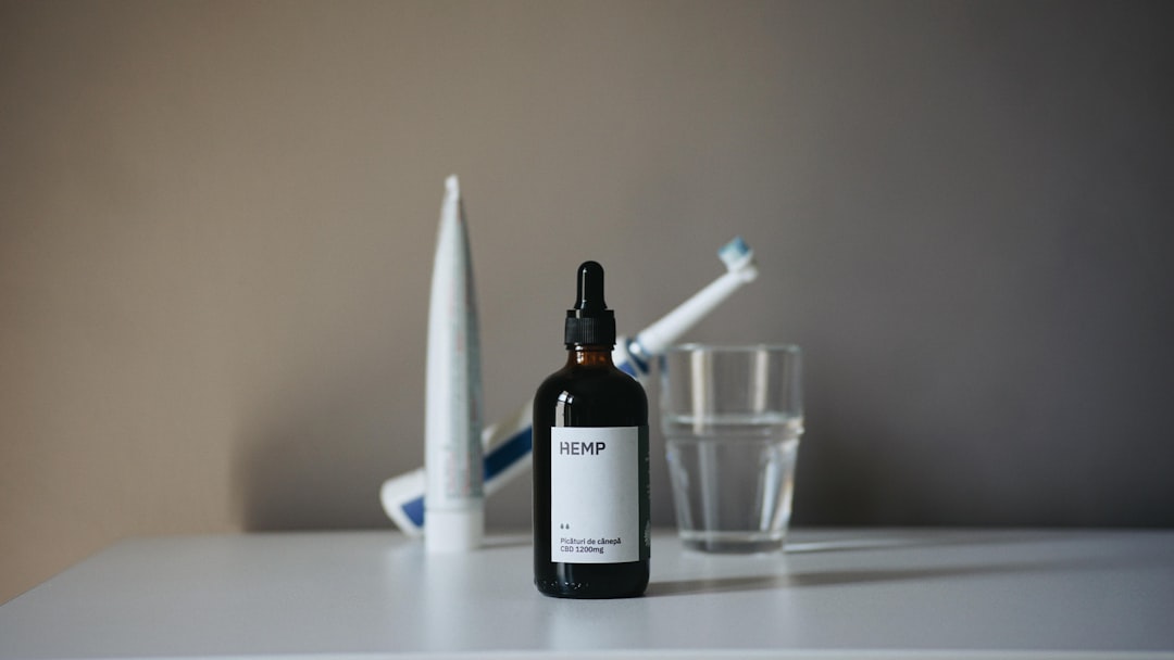a bottle of liquid sitting on top of a table next to a toothbrush,
