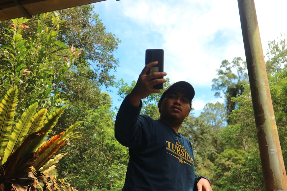 Un hombre tomándose una foto con un teléfono celular