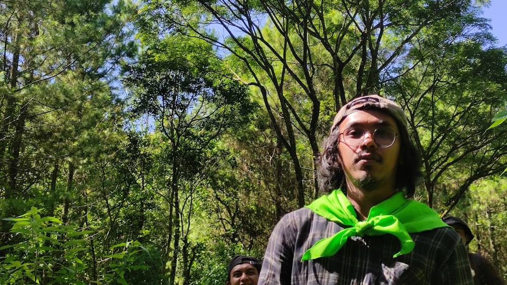 um homem usando uma gravata borboleta verde na floresta