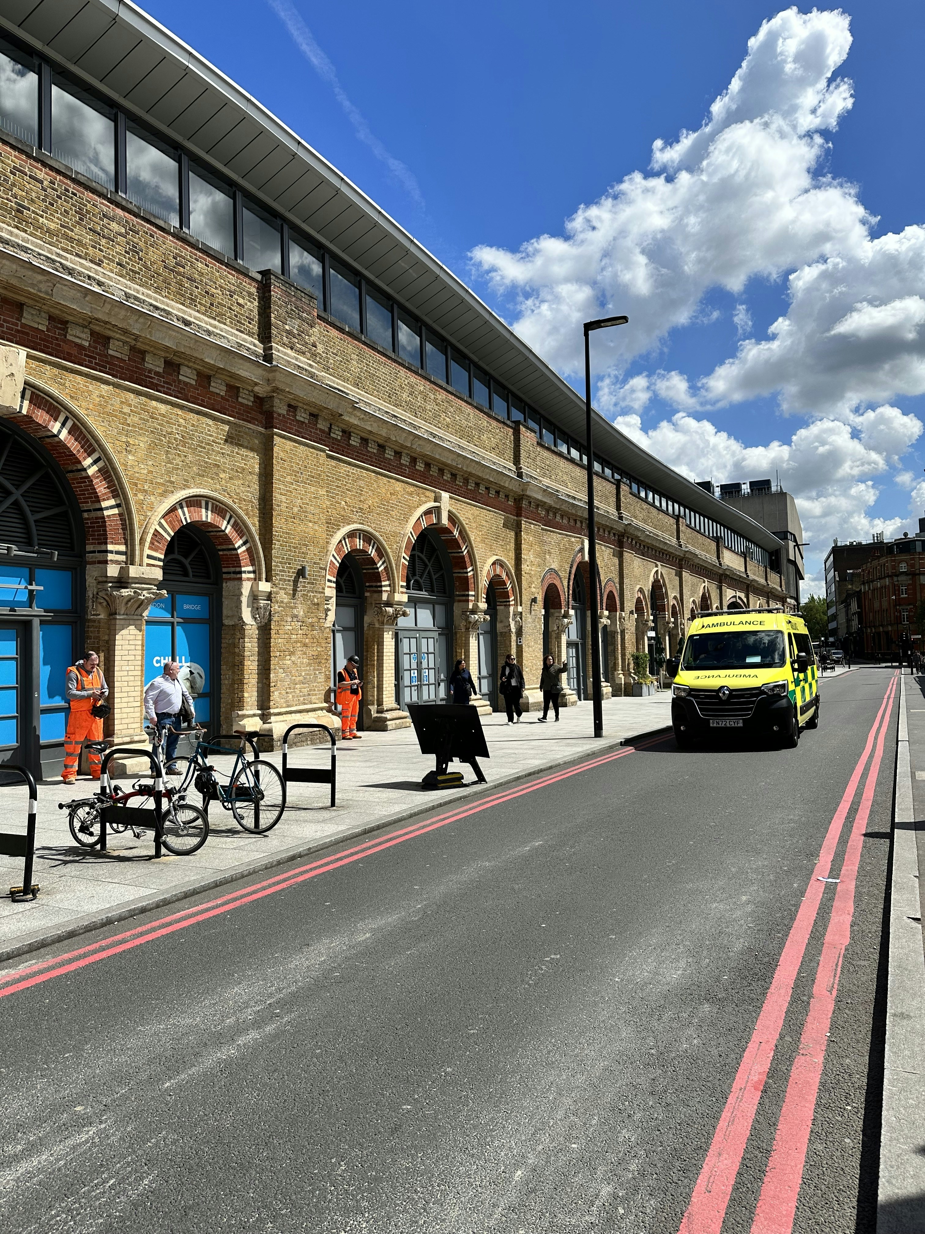 Uma van amarela estacionada em frente a uma estação de trem