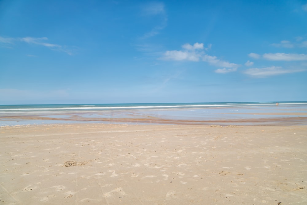 a sandy beach with waves coming in to shore