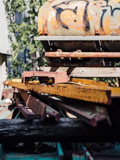 a rusted train car sitting on top of a pile of junk