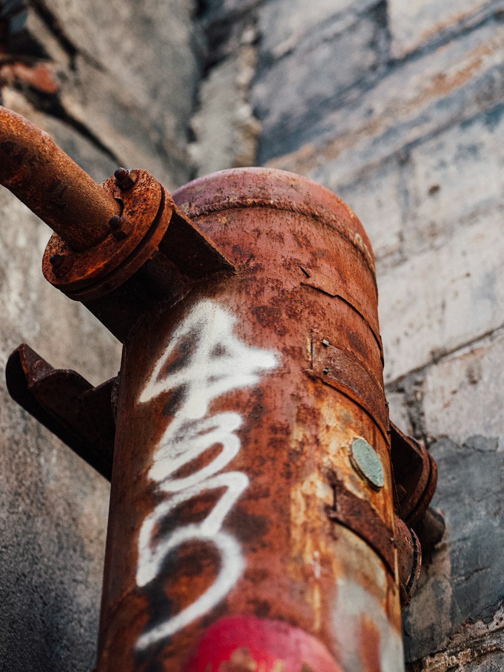 an old rusted pipe with graffiti on it