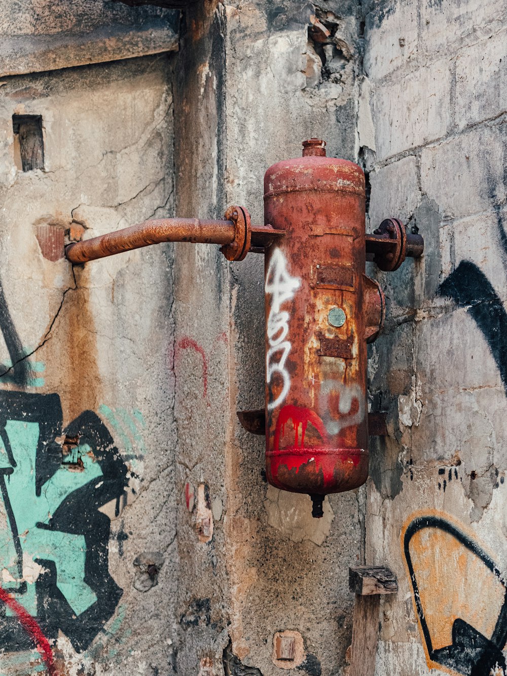 a rusted fire hydrant on the side of a building