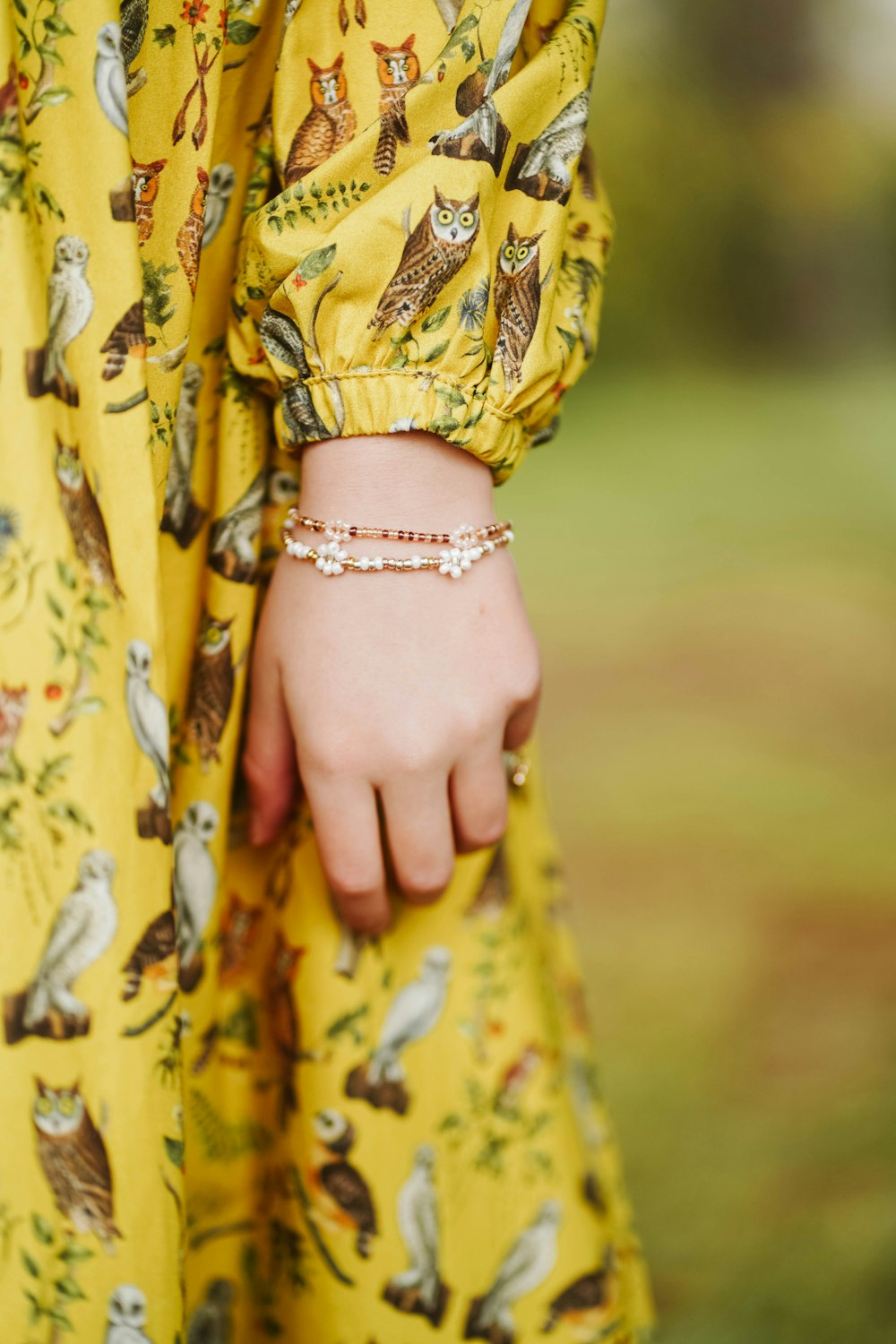 a woman wearing a yellow dress and a bracelet