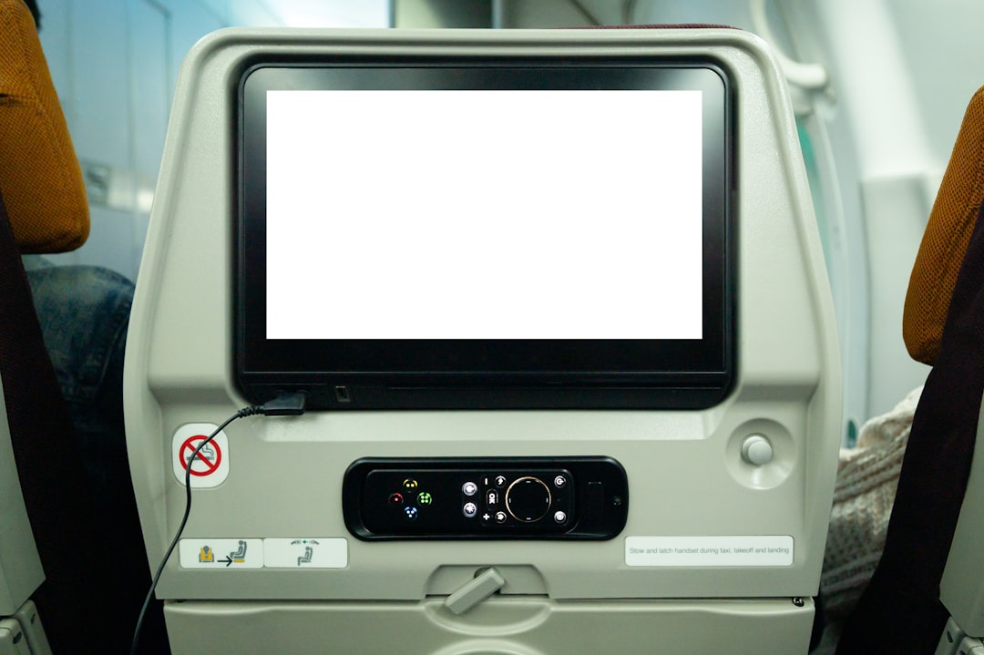 a computer monitor sitting on top of an airplane seat, Blank advertising billboard at airport,mockup poster media template ads display