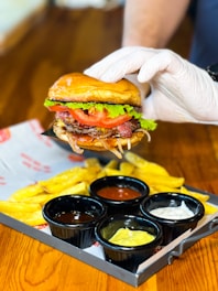 a person in white gloves is holding a large sandwich