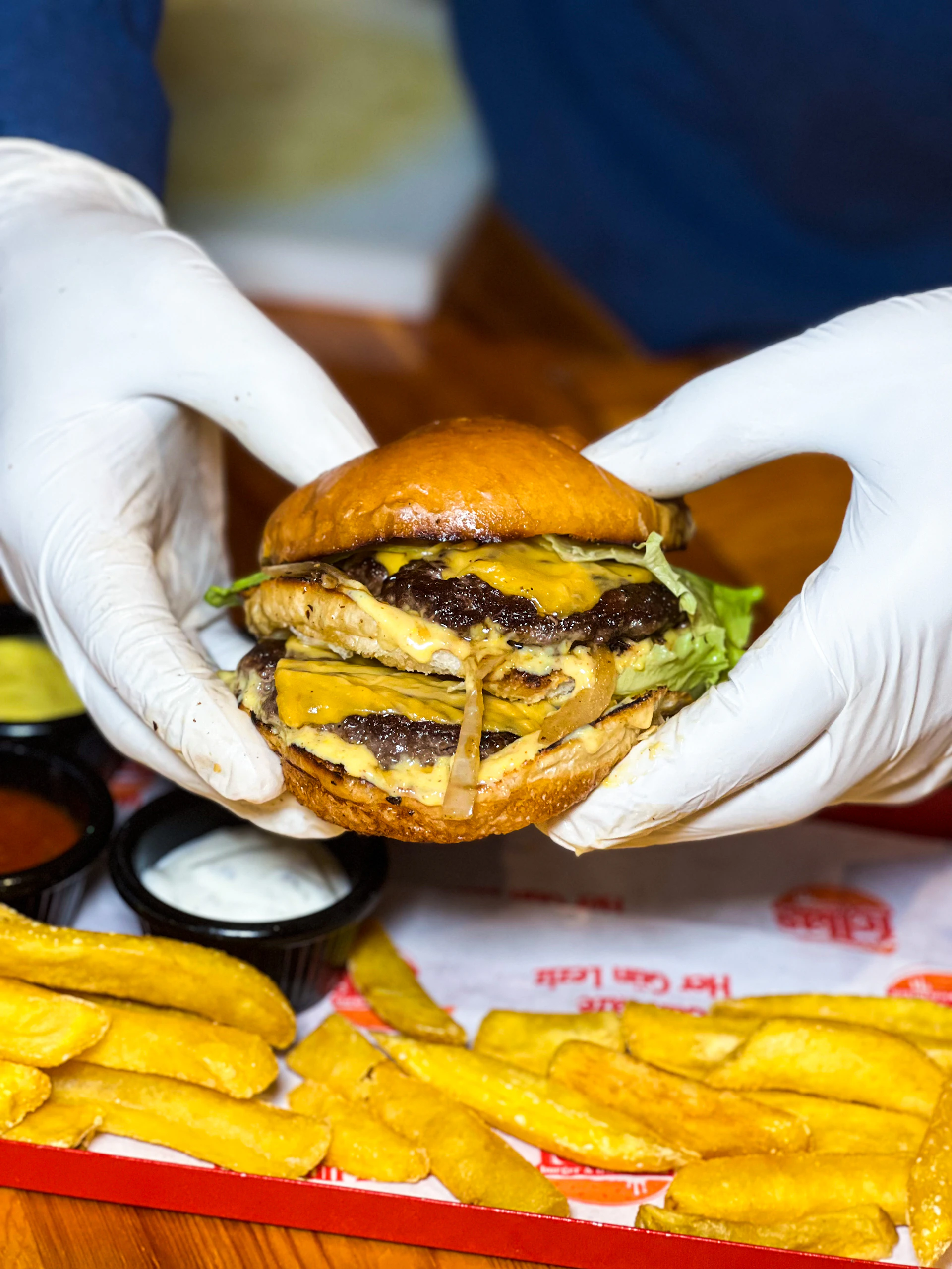 a person in white gloves is holding a hamburger
