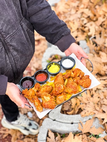 a person holding a tray of food in their hands