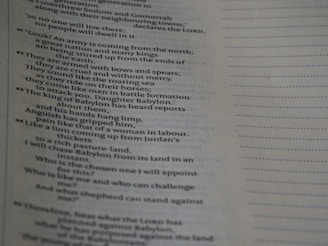 Close-up of a page from a printed book. The text is in English and appears to be a passage discussing various subjects related to a great army attacking Babylon. The page is well-lit, with the text predominantly in black on a white background. The right side of the page features a dotted line pattern.