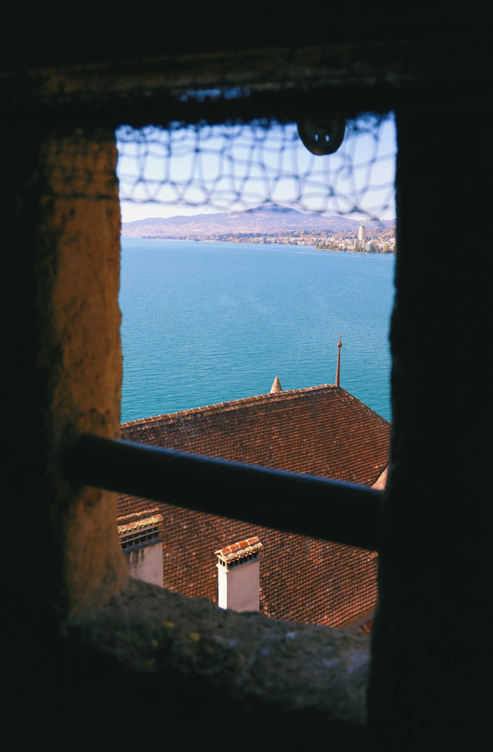 Blick durch ein Fenster auf ein Gewässer