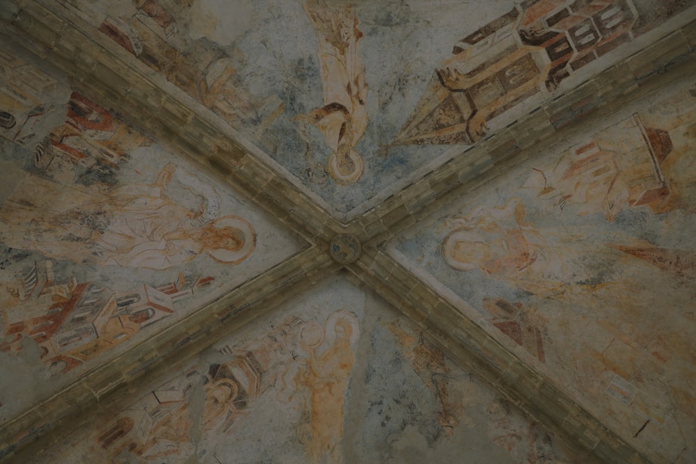 a close up of a ceiling with paintings on it