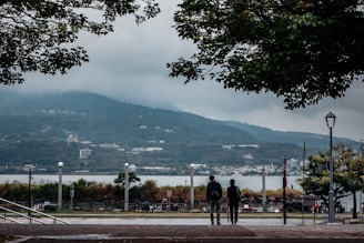 Phyllis and Ryan Hartford standing on a scenic ridge overlooking multi-acre homesites with Mt Rainier in the background.
