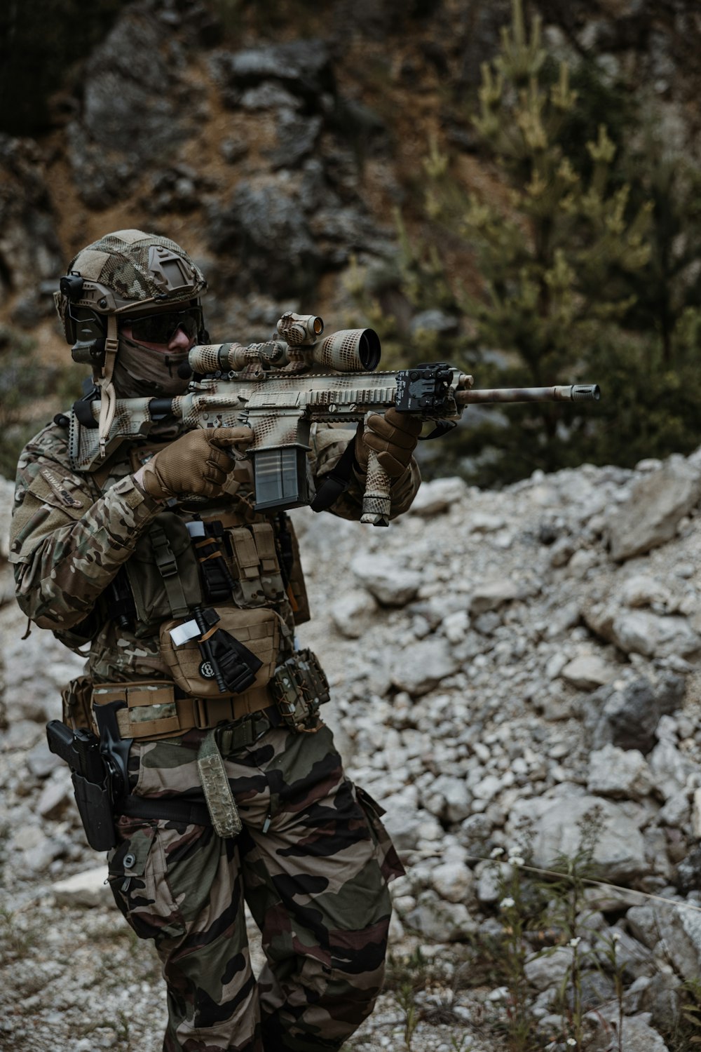 a man in camouflage holding a rifle in his hand