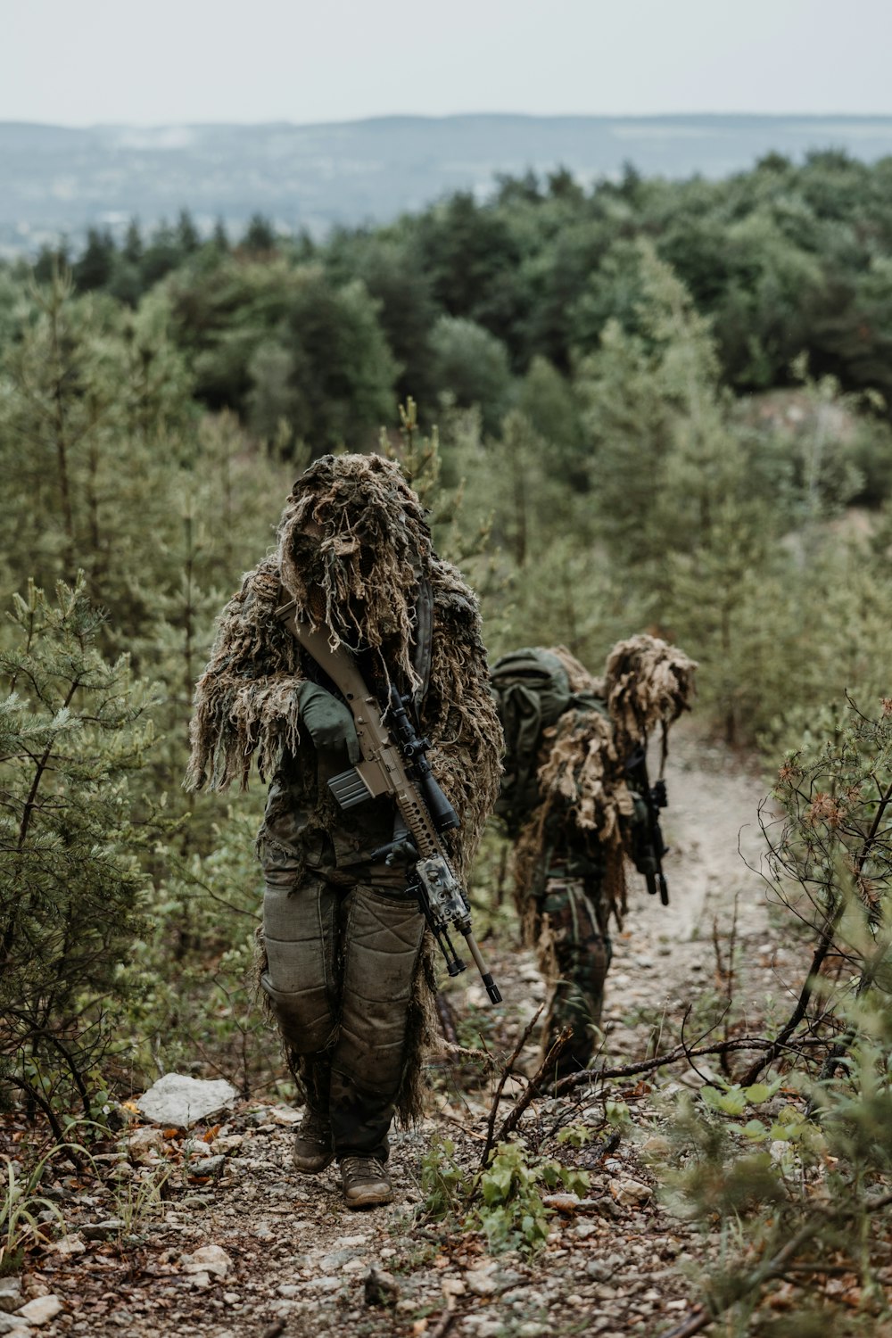 a couple of men walking down a dirt road