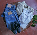 Stylish men’s and women’s clothing laid out on a wooden table.