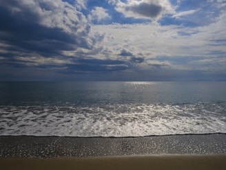 A serene ocean view with gentle waves lapping against a sandy shore.
