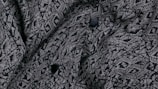 A close-up of intricate fabric patterns on a designer shirt.