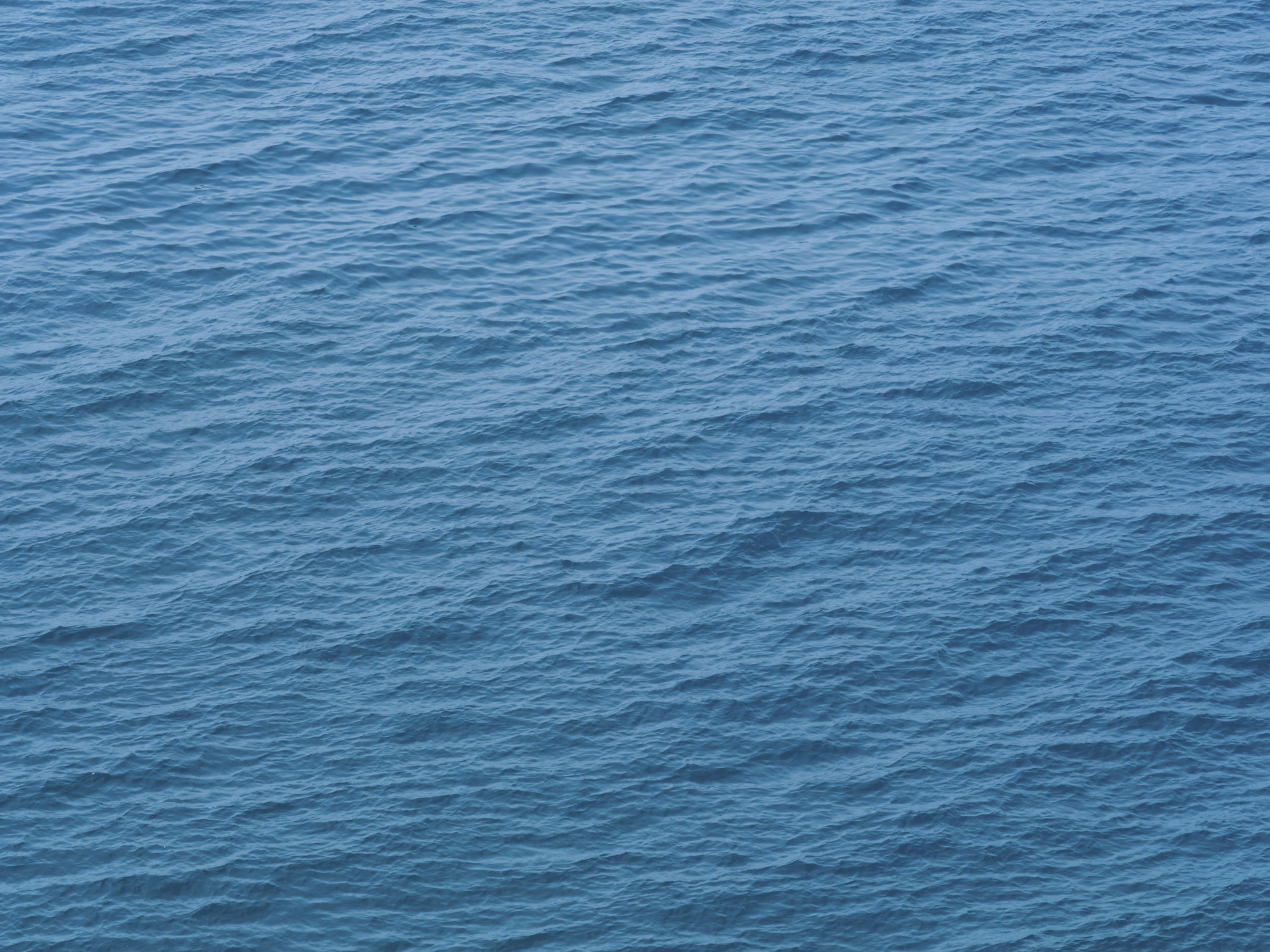 a lone boat floating in the middle of the ocean