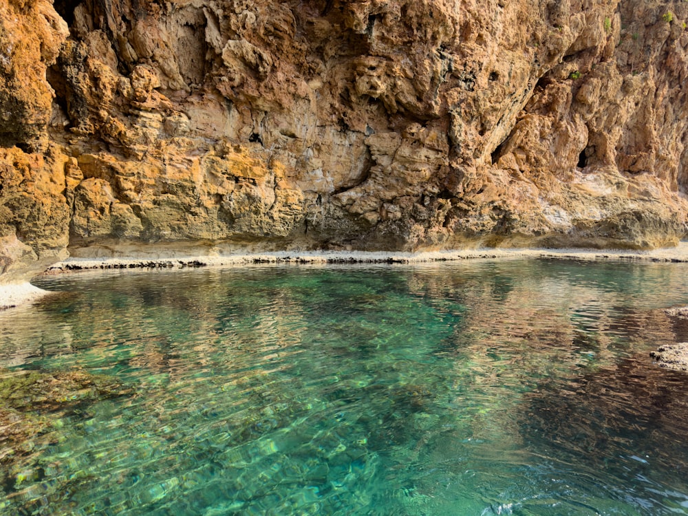 un cuerpo de agua rodeado por un acantilado rocoso
