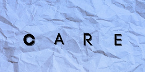 Letters spelling out the word 'CARE' are placed on a textured, crumpled background with a bluish tint.
