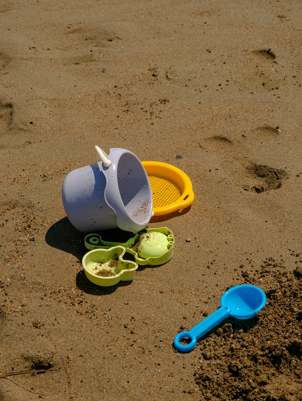 a shovel and a watering can on a beach