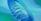 An abstract, spiraling blue form set against a smooth gradient background of blues and greens. The structure has a fluid, wave-like appearance with a contemporary, artistic design.