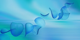 Abstract blue petals or leaves appear to be floating gracefully across a gradient background that transitions from blue to green. The image has a serene and flowing aesthetic with soft, blurred lines suggesting movement.