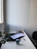 Calm office corner with soft natural light and a closed laptop beside a tidy stack of papers.