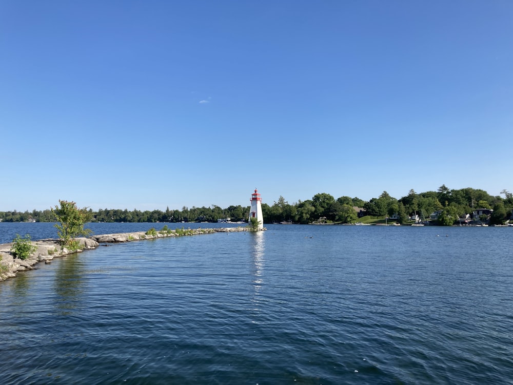 a body of water with a light house in the distance