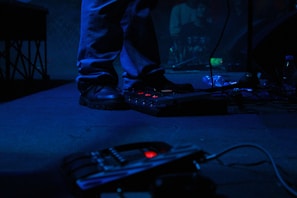 A musician testing a soundcircuit-designed pedal on stage with vibrant lighting.