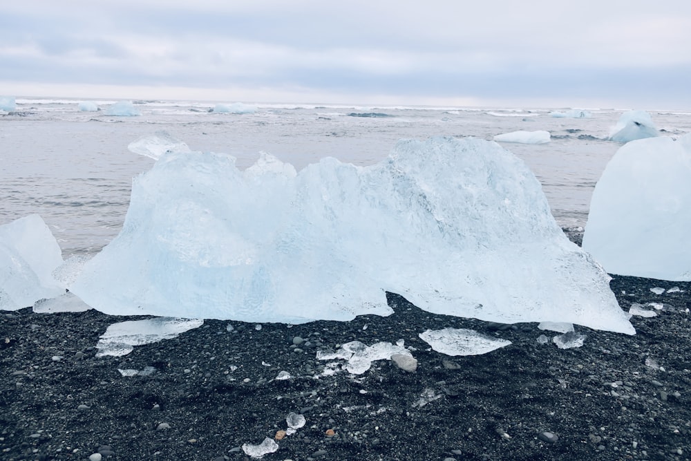 a large iceberg sitting on top of a black beach