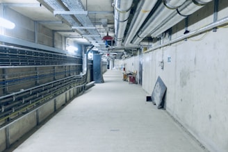a long hallway in a building with lots of pipes
