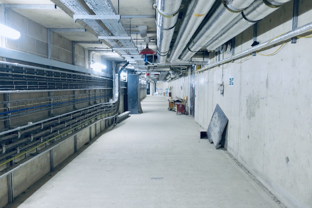 a long hallway in a building with lots of pipes