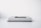 A minimalist scene featuring two identical light gray books stacked horizontally on a flat surface with a smartphone placed on top of them. The background is a clean white, enhancing the simplicity of the arrangement.