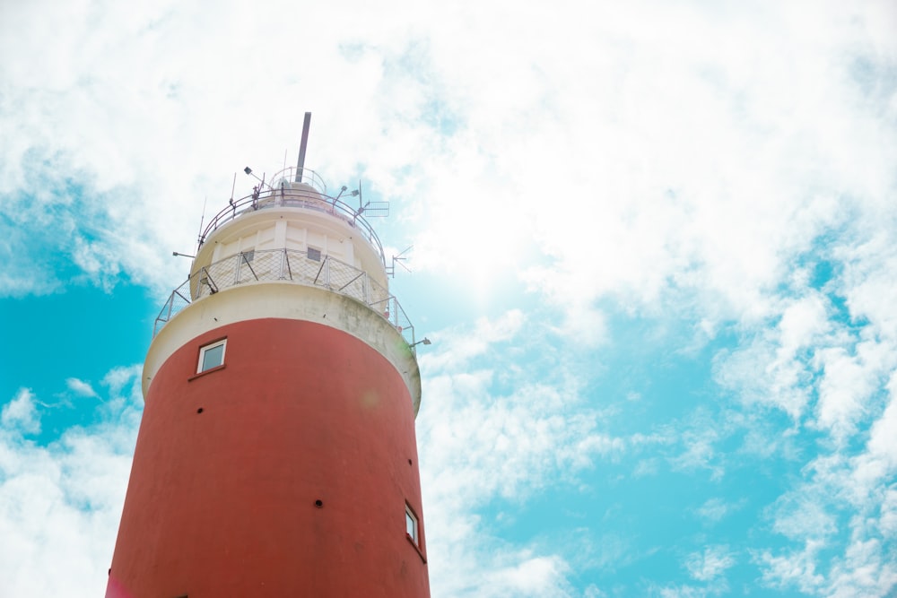 a red and white lighthouse under a blue sky