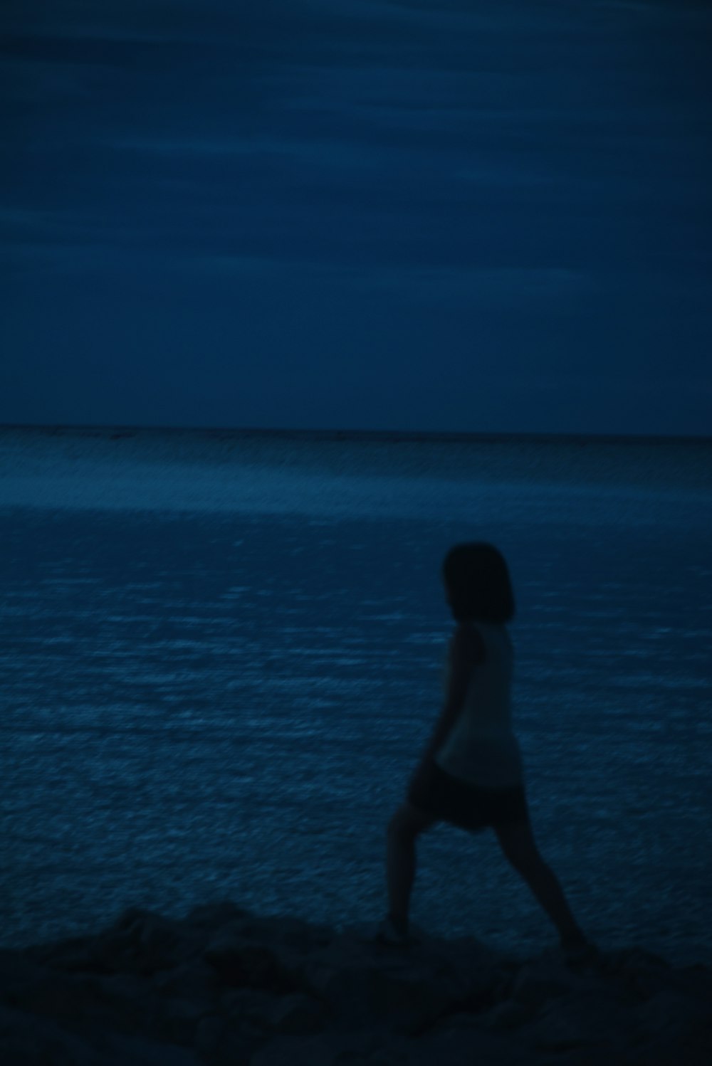 a person standing on a beach at night