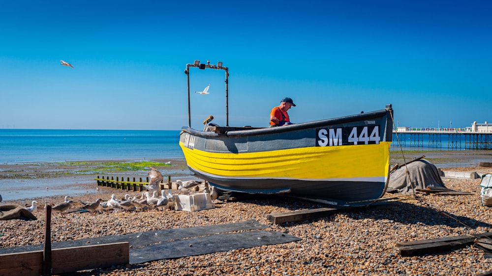 a man is sitting in a boat on the beach