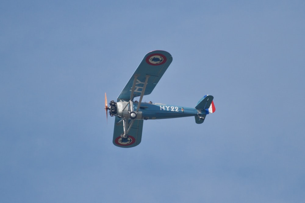 a small airplane flying through a blue sky