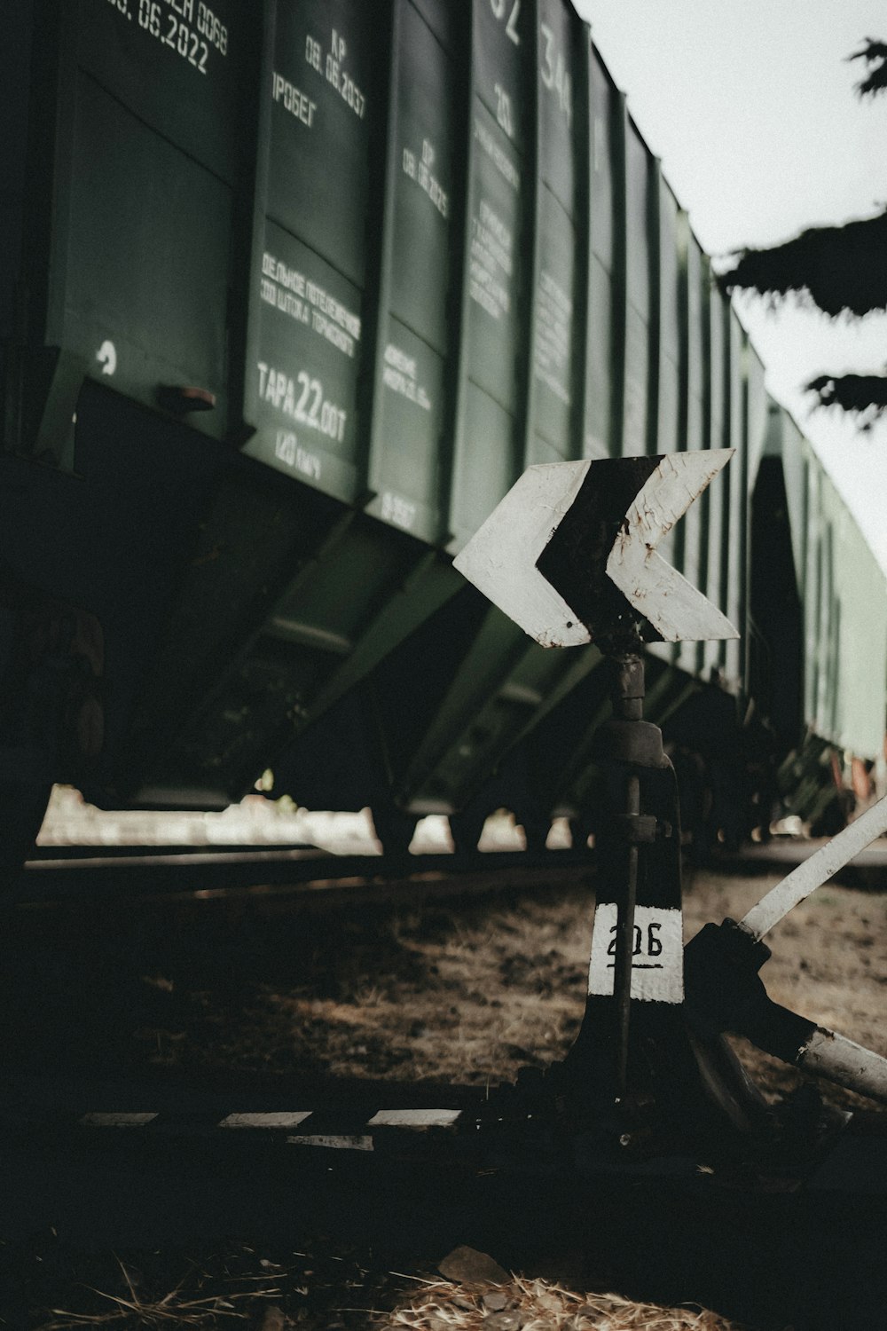 a railroad crossing with a train in the background