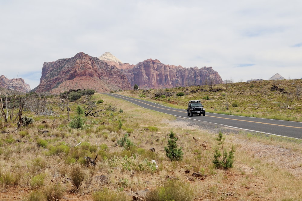 a truck driving down a road in the desert